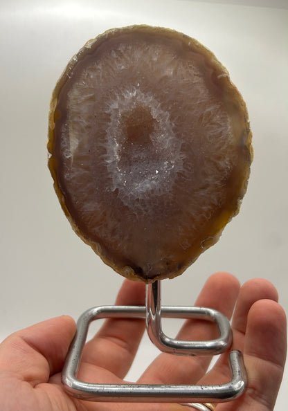 Mezzo geode di agata lucidato su piedistallo
